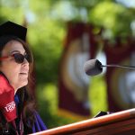 Dean Donna Rapaccioli at podium in purple robe