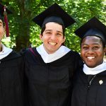 Three male graduates pose for a picture.