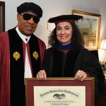 Stevie Wonder with woman holding his framed honorary degree