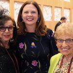 Three women smile for a photo